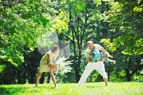 Image of happy young couple with their children have fun at park