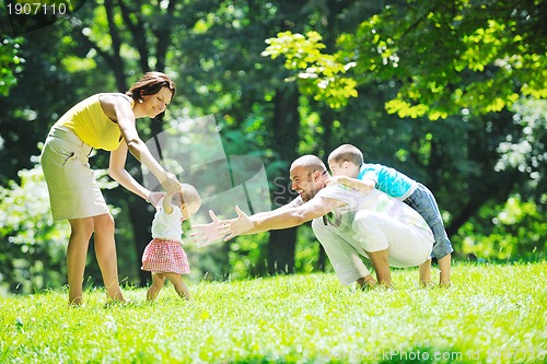 Image of happy young couple with their children have fun at park