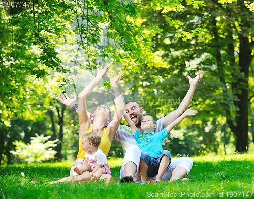 Image of happy young couple with their children have fun at park