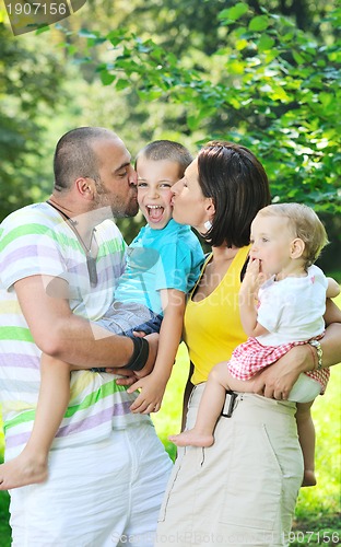 Image of happy young couple with their children have fun at park