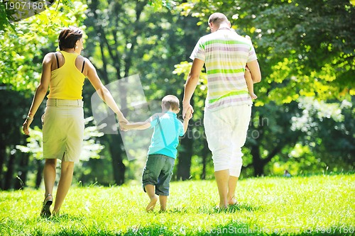 Image of happy young couple with their children have fun at park
