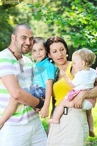 Image of happy young couple with their children have fun at park