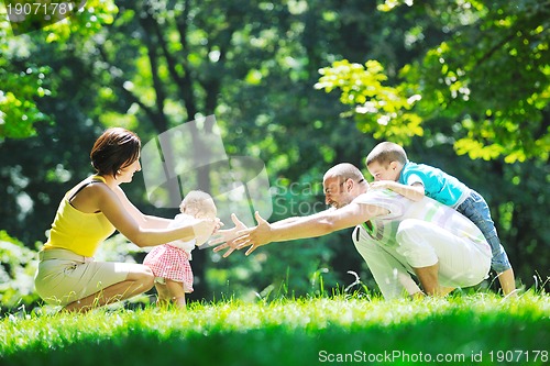 Image of happy young couple with their children have fun at park