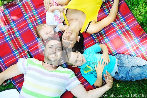 Image of happy young couple with their children have fun at park