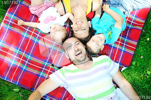 Image of happy young couple with their children have fun at park