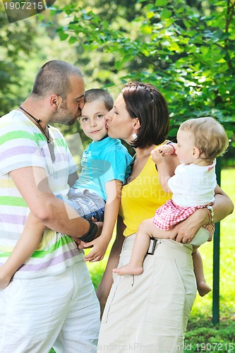 Image of happy young couple with their children have fun at park