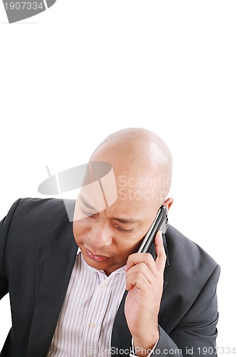 Image of Portrait of a serious businessman talking on mobile phone over w