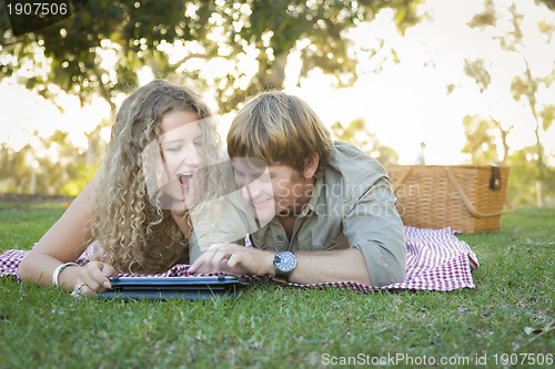 Image of Attractive Loving Couple Using a Touch Pad Outside