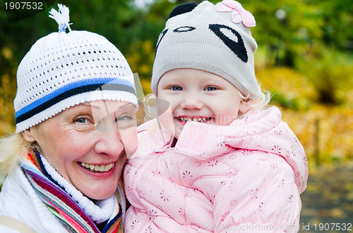 Image of grandmother with the grand daughter in autumn park