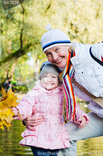 Image of grandmother with the grand daughter in autumn park