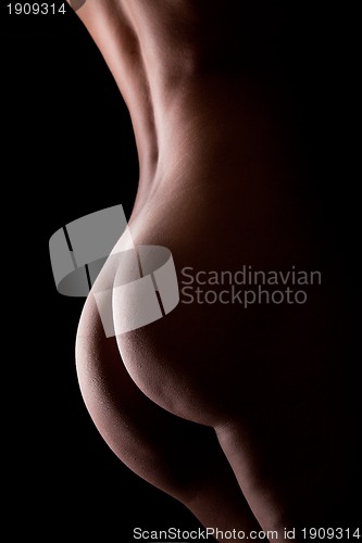 Image of Beautiful ass of young woman over dark background