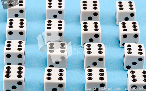 Image of white gamble dice black dots on blue background 