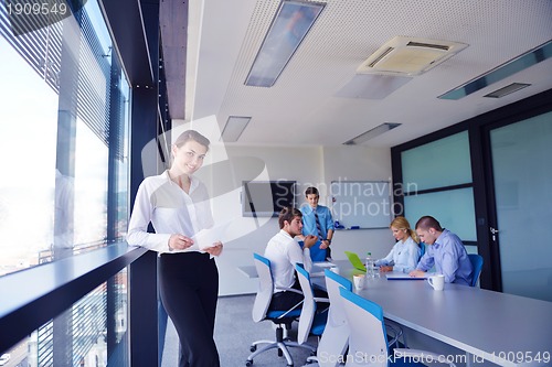 Image of business woman with her staff in background at office