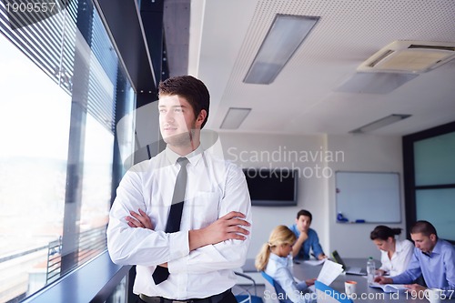 Image of business man  on a meeting in offce with colleagues in backgroun