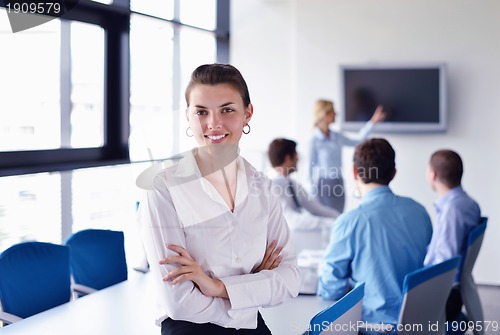 Image of business woman with her staff in background at office
