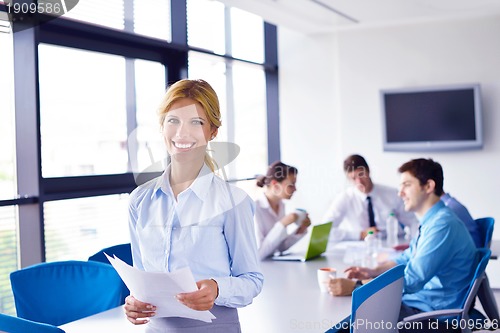 Image of business woman with her staff in background at office