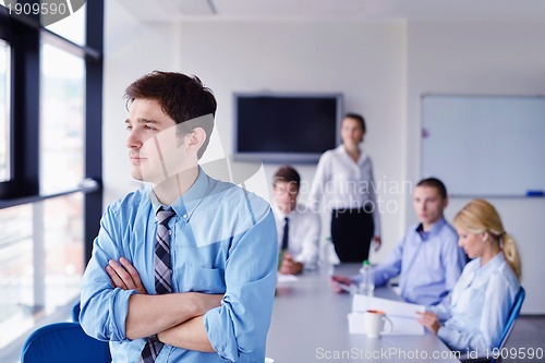 Image of business man  on a meeting in offce with colleagues in backgroun