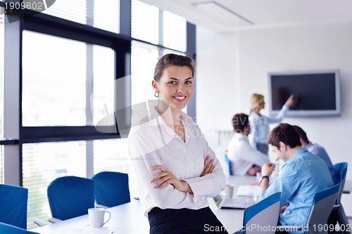 Image of business woman with her staff in background at office