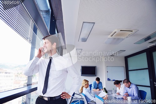 Image of business man  on a meeting in offce with colleagues in backgroun