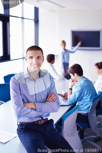 Image of business man  on a meeting in offce with colleagues in backgroun