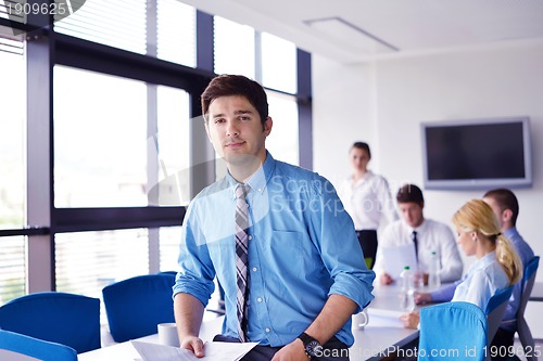 Image of business man  on a meeting in offce with colleagues in backgroun