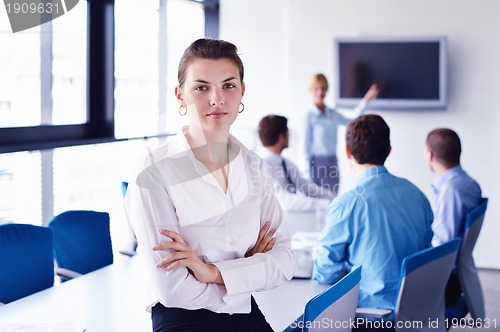 Image of business woman with her staff in background at office