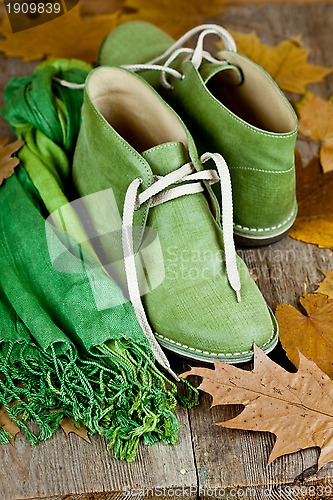 Image of green leather boots, scarf and yellow leaves