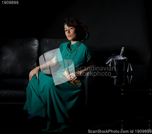 Image of Beautiful girl sitting on a sofa