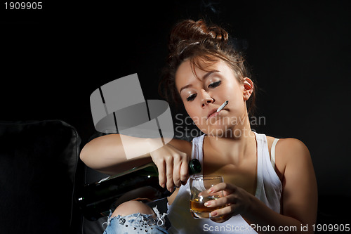 Image of Woman smoking while pouring a drink