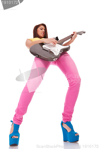 Image of passionate young woman guitarist playing