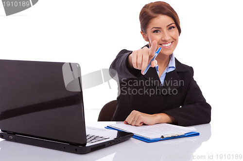 Image of businesswoman  at desk pointing