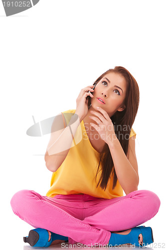 Image of worried woman sitting and talking on phone
