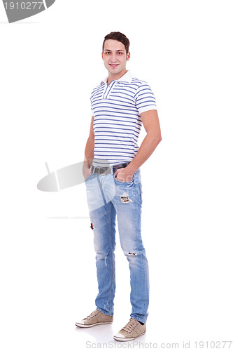 Image of young man standing with hands in pockets 