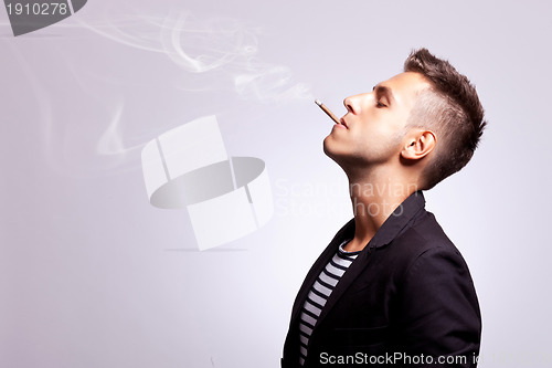 Image of casual fashion man smoking a cigar