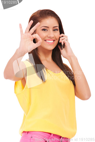 Image of casual woman with phone and ok gesture