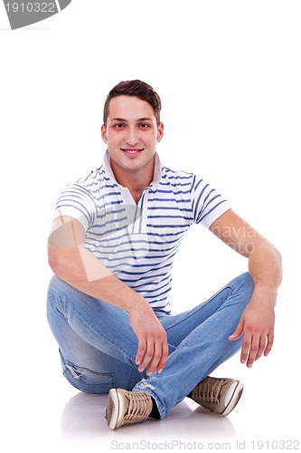 Image of young casual happy man seated 