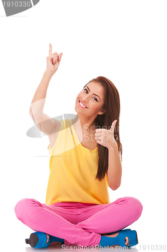 Image of casual woman pointing up and make ok