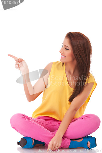 Image of smiling casual woman showing something 