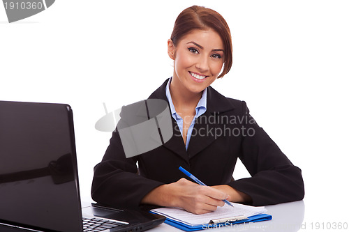 Image of business woman at her desk writing