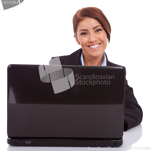 Image of smiling young business woman using laptop