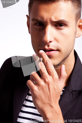 Image of young man smokes a cigarette 