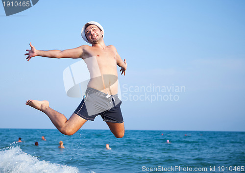 Image of man jumping of joy on the beach