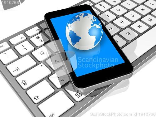 Image of world globe on a mobile phone on a computer keyboard
