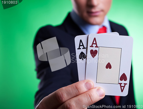 Image of business man holding a pair of aces