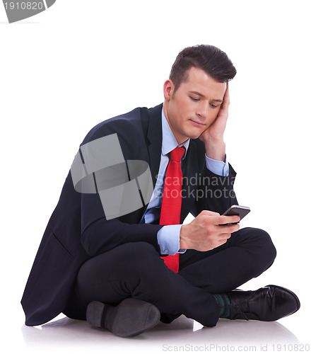 Image of pensive young business man is reading a text message