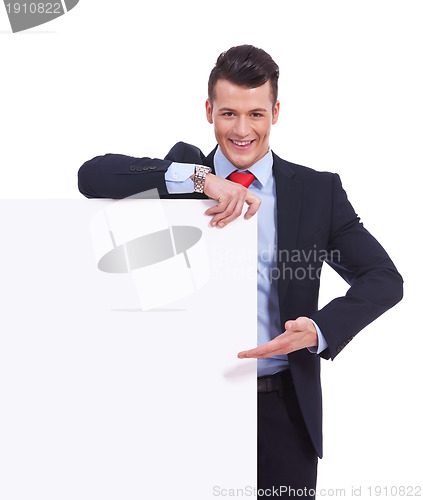 Image of Young business man presenting a  blank board 