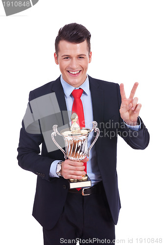 Image of young business man winning a big trophy 