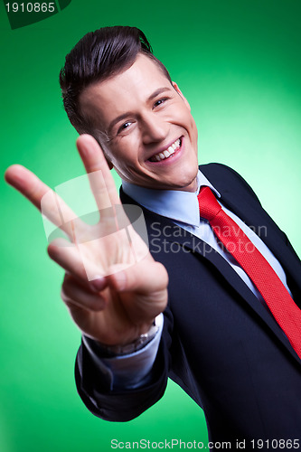 Image of business man in a suit giving the victory sign