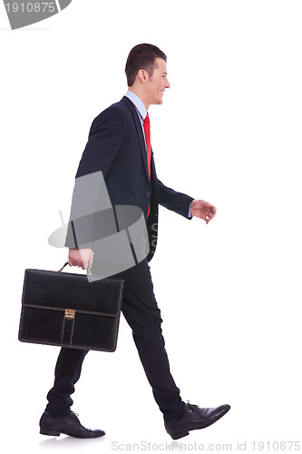 Image of side view business man holding brief case and walking 