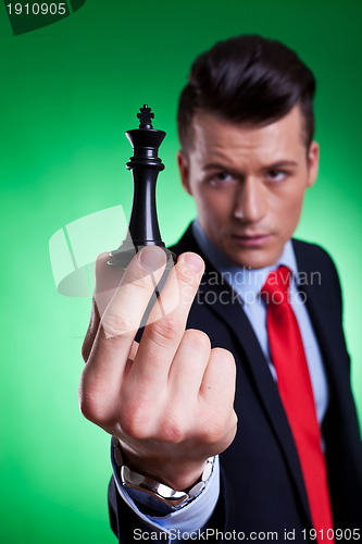 Image of  business man holding and looking at the black king